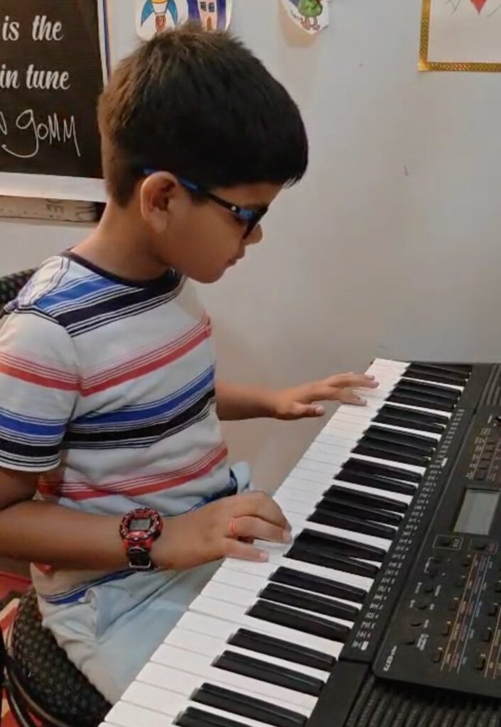 Anwit practicing keyboard during a beginner music lesson