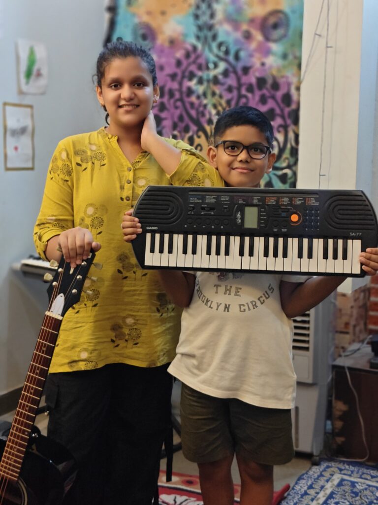 Musical duo Ishi and Anwit performing with guitar and keyboard, young rising musicians creating harmony.