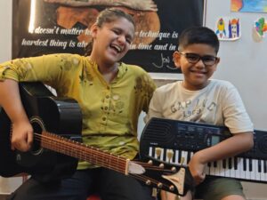 Young musical duo Ishi and Anwit, talented brother and sister musicians playing guitar and keyboard together.