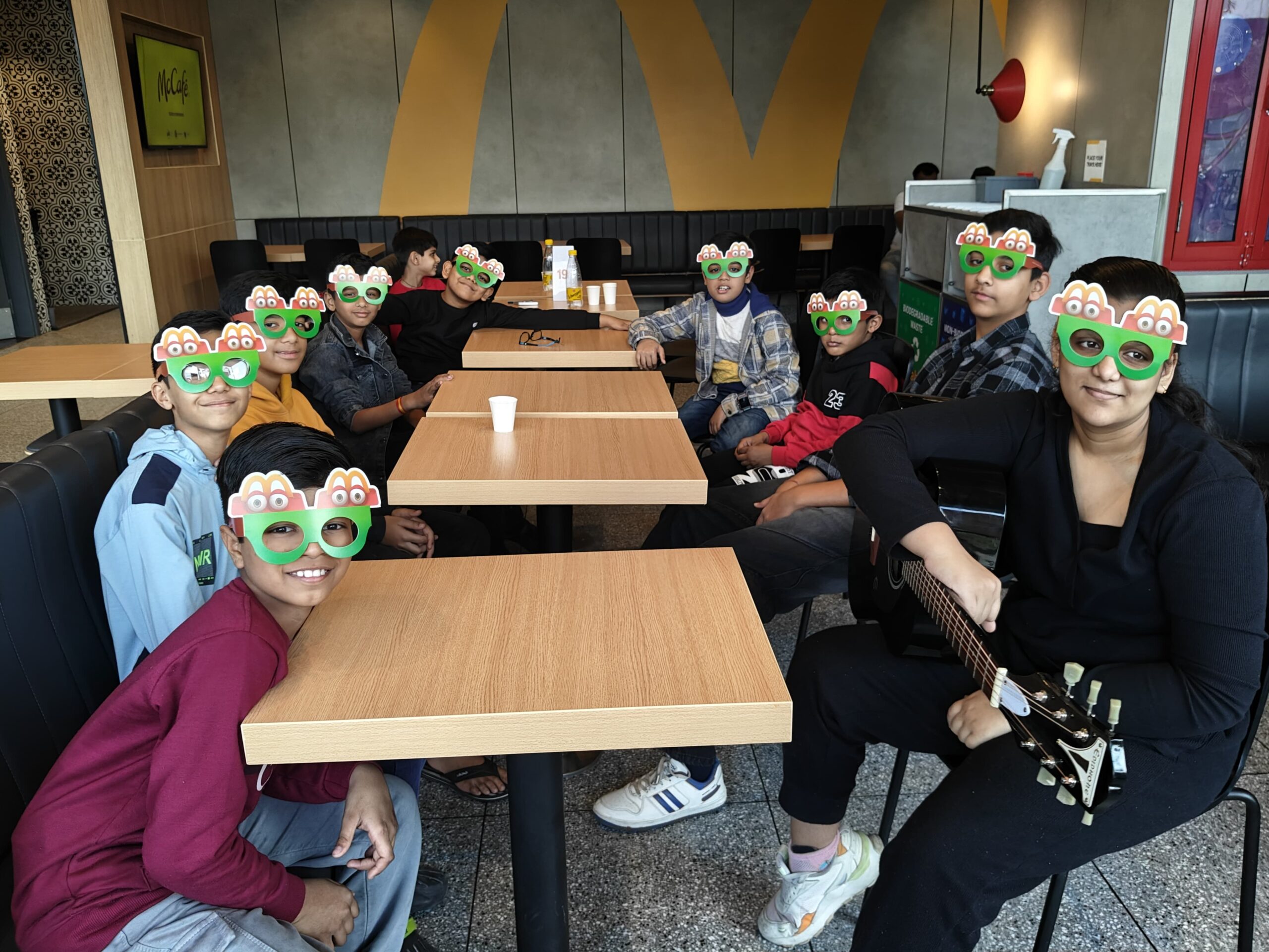 Ishi and friends jamming on guitars in a McDonald’s cafe