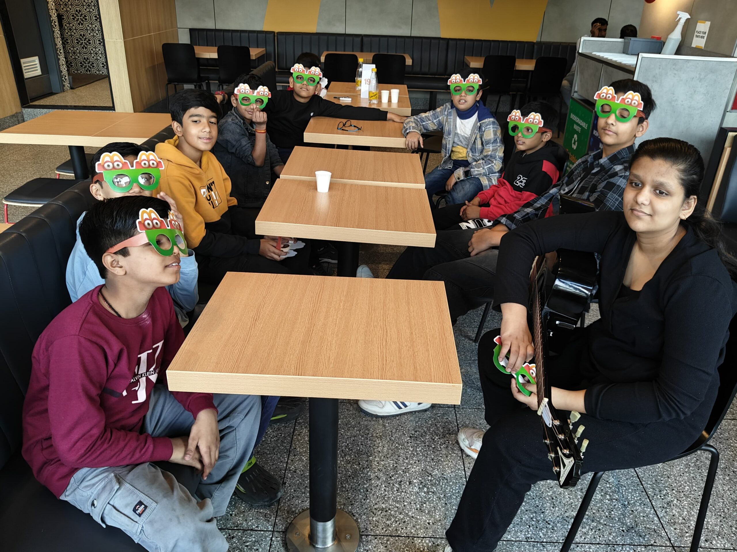 Ishi and friends jamming on guitars in a McDonald’s cafe