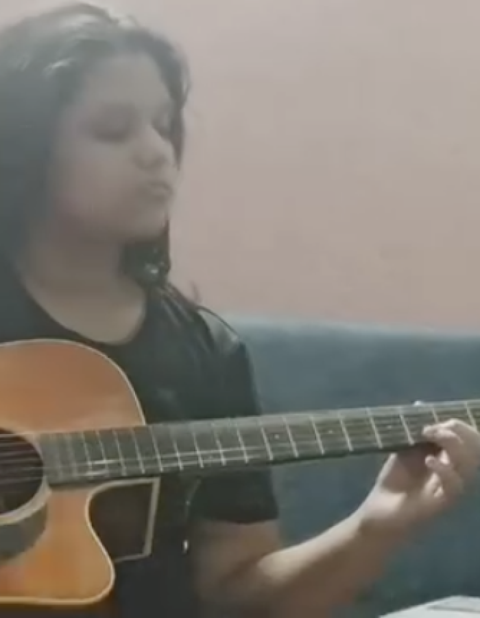 Ishi performing instrumental music on guitar as part of a musician duo.